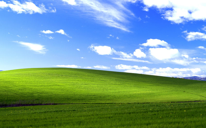 Windows XP desktop background of a green hill and blue sky