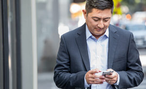 Image of a man checking his phone.