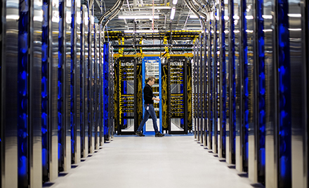 Image for: Image of a man walking through a datacenter.