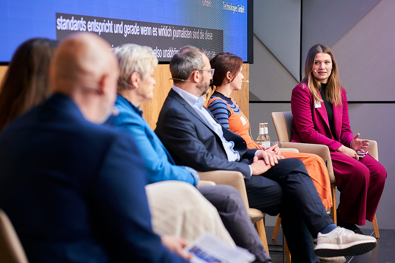 Foto von Roberta Schmid von NewsGuard auf der Bühne der Explained Cybersecurity in Berlin