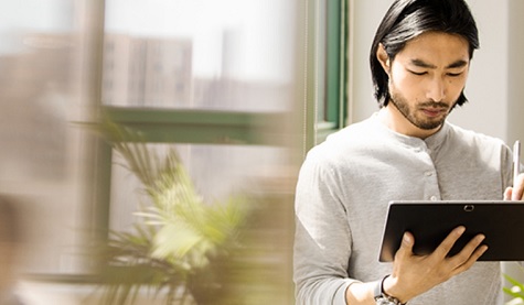 Ein Mann hält ein Tablet in seinen Händen