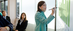 Eine Frau schreibt in einem Meeting auf einem Surface Hub