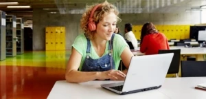 Eine junge Lehrerin sitzt am Laptop und bereitet sich auf das "RotznasenRadio" vor.