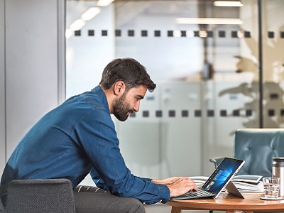 Ein Mann im Sessel arbeitet an einem Surface Devic