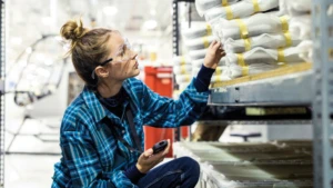 Junge Frau arbeitet in einer Fabrik.