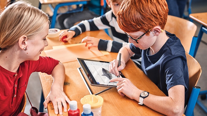 Zwei Schulkinder bei der Arbeit an einem Laptop