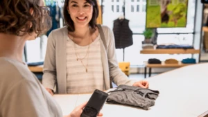 Eine Frau zahlt an der Kasse mit ihrem Smartphone.