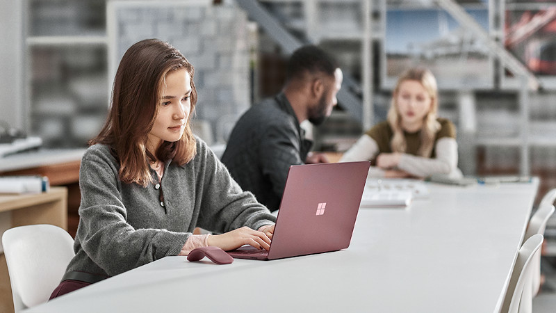 Eine Studentin im Klassenzimmer mit Surface Laptop.