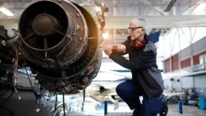 Eine Frau arbeitet in einer Fertigungshalle an einer Flugzeugturbine