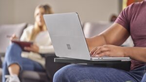 Ein Student mit einem Laptop auf den Knien