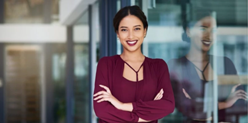 Frau in roter Kleidung neben einer Glaswand. 