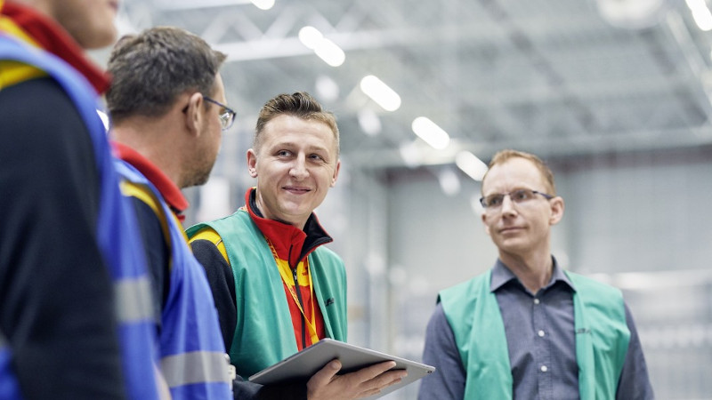 Vier Mitarbeiter von DHL im Gespr&auml;ch