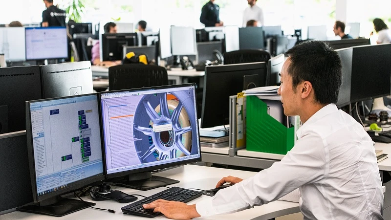 Ein Ingenieur arbeitet an seinem Schreibtisch im B&uuml;ro der Rennwagenfabrik