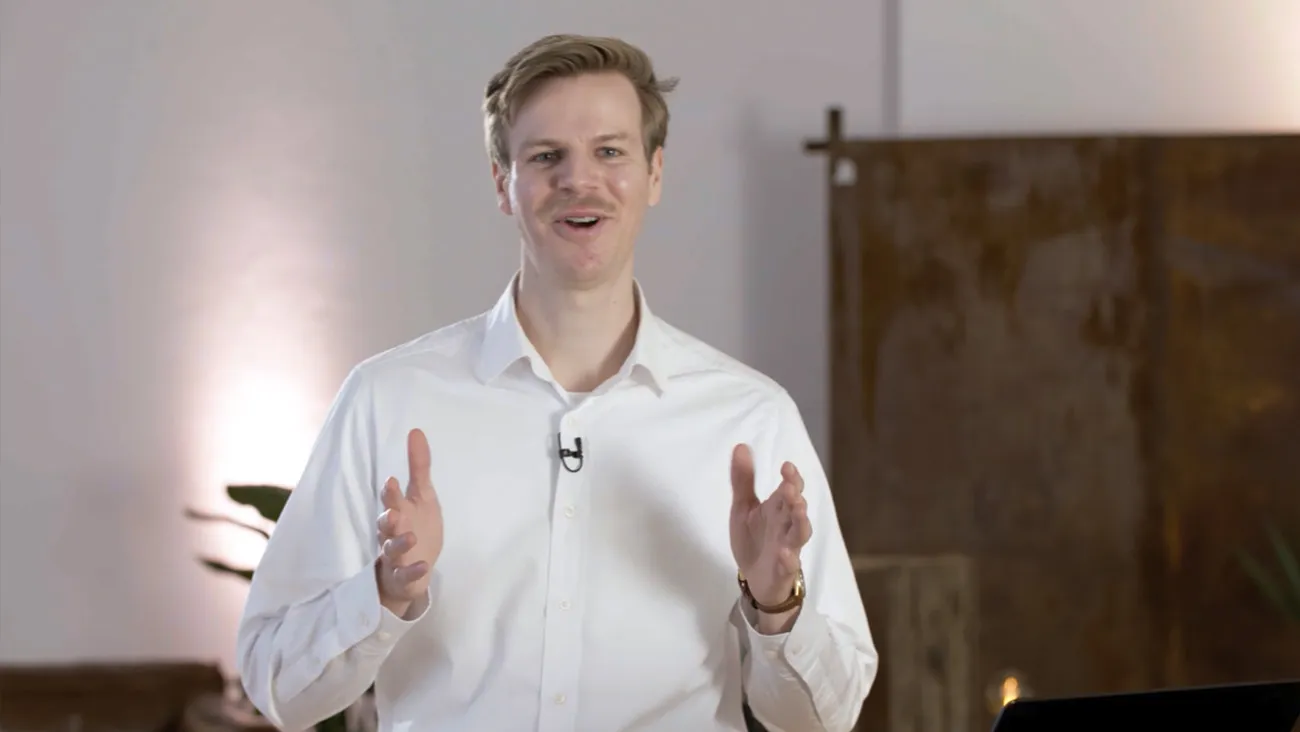 Ein Mann steht als Moderator in einem Büro.