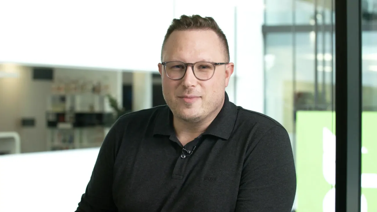 Ein Mann steht als Moderator in einem Büro.