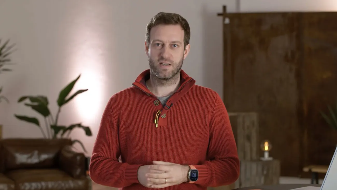 Ein Mann steht als Moderator in einem Büro.