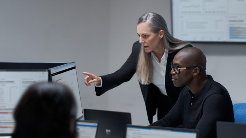 CISO (chief information security officer) collaborating with a practitioner in a security operations center