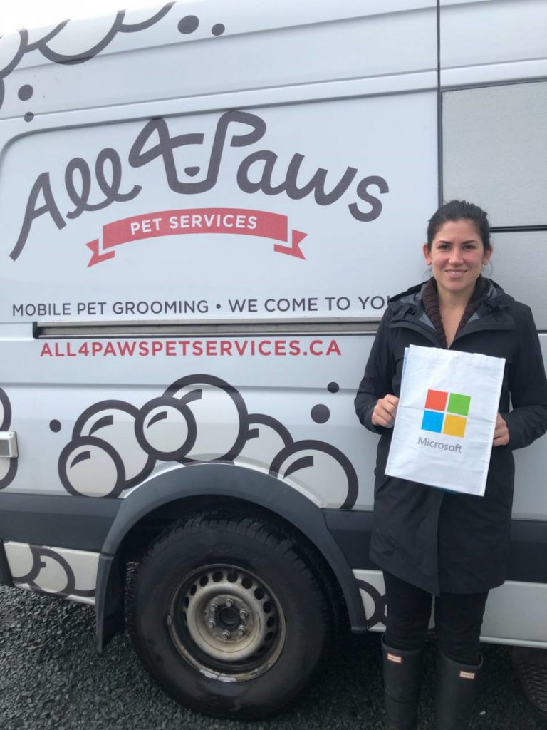 Photograph Kelsey Johnston, founder of All 4 Paws, standing in front their van