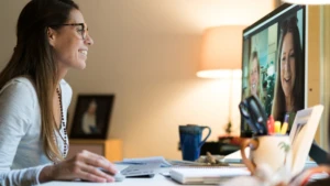 Woman using Skype video conferencing to conduct a work meeting.
