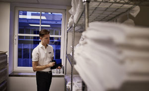 Image of a hotel worker checking supplies in a supply room.