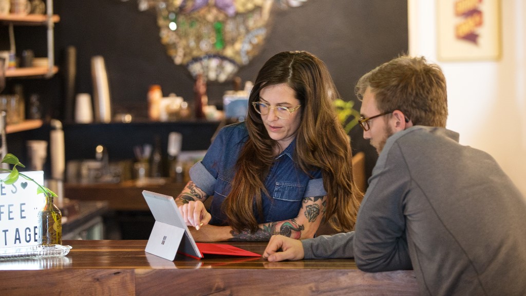 A cafe owner talks to an employee with a Surface device