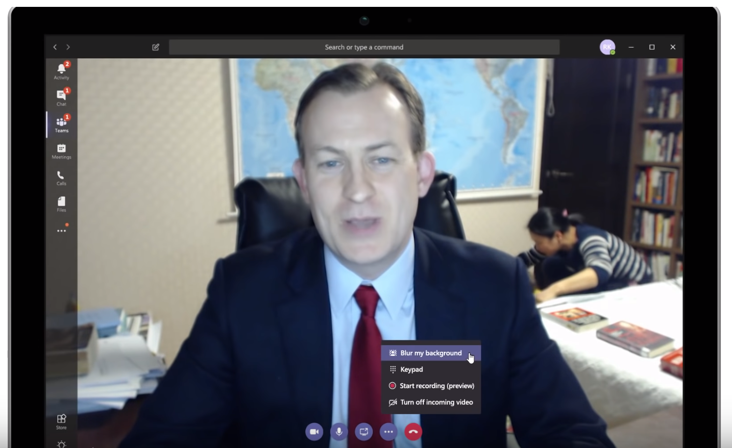 Man on a conference call with children in background, using the background blur functionality in Microsoft Teams.