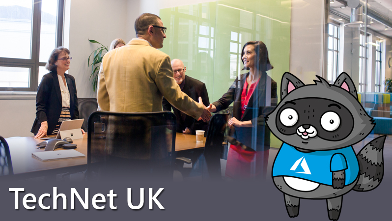 A woman and a man shaking hands in a conference room, with a picture of Bit the Raccoon on the right of the image.