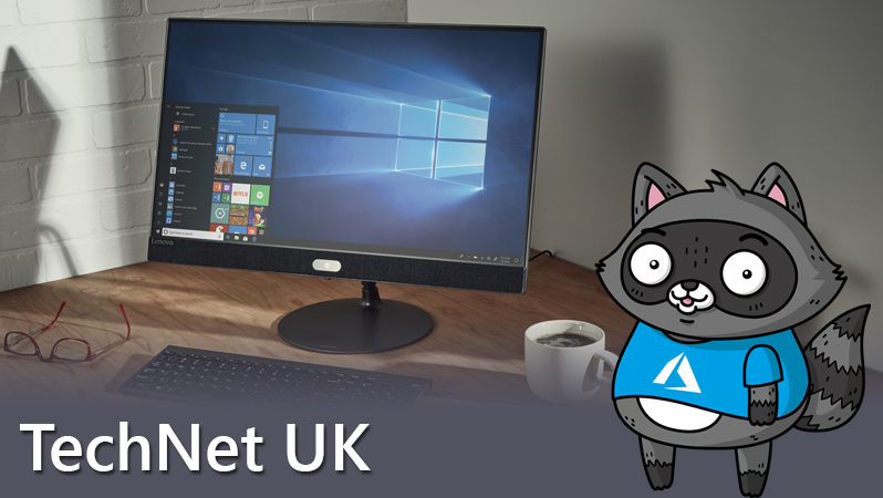 Bit the Raccoon standing next to a Windows 10 desktop computer.