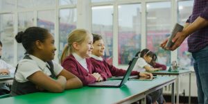 Students in front of laptops in a classroom.