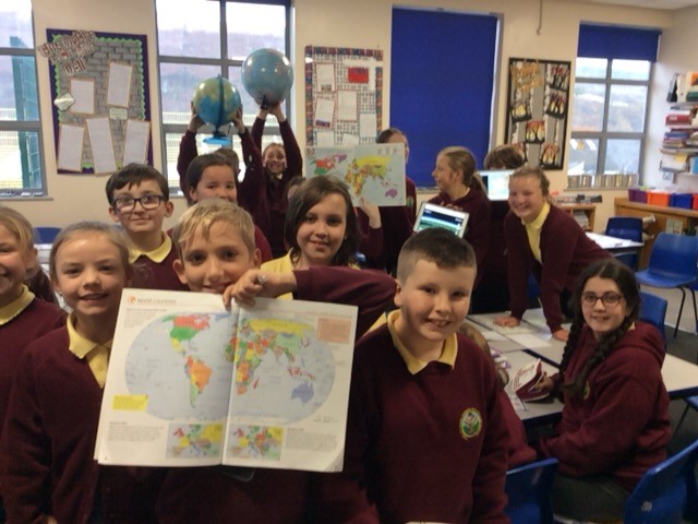 Darran Park Primary School students holding up globes and maps of the worlds