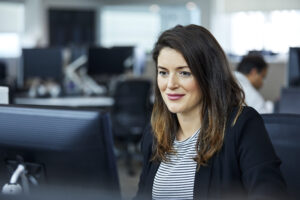 Smiling businesswoman using computer in office