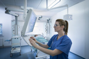 Nurse inspecting screen in intensive care unit in hospital setting