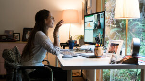 A woman actiively participates in a virtual work meeting from her home office