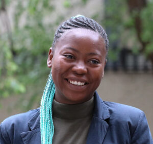 Woman outside with trees behind her