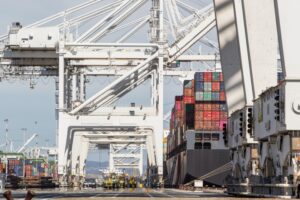 Close up shot of shipping port; container ships being loaded.