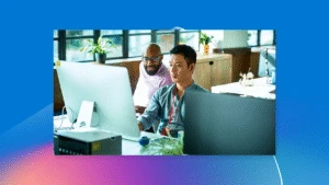 Two developers at desk in front of computer.