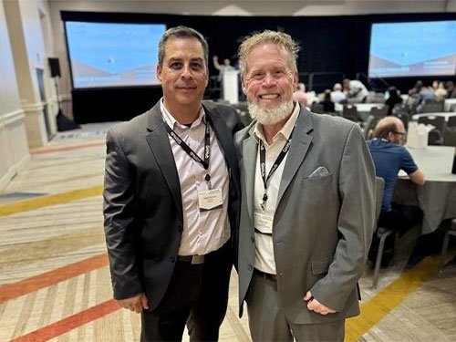 Two men positioned next to each other at a conference.