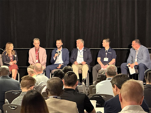 A group of people seated in chairs, engaged in discussion at a conference setting.