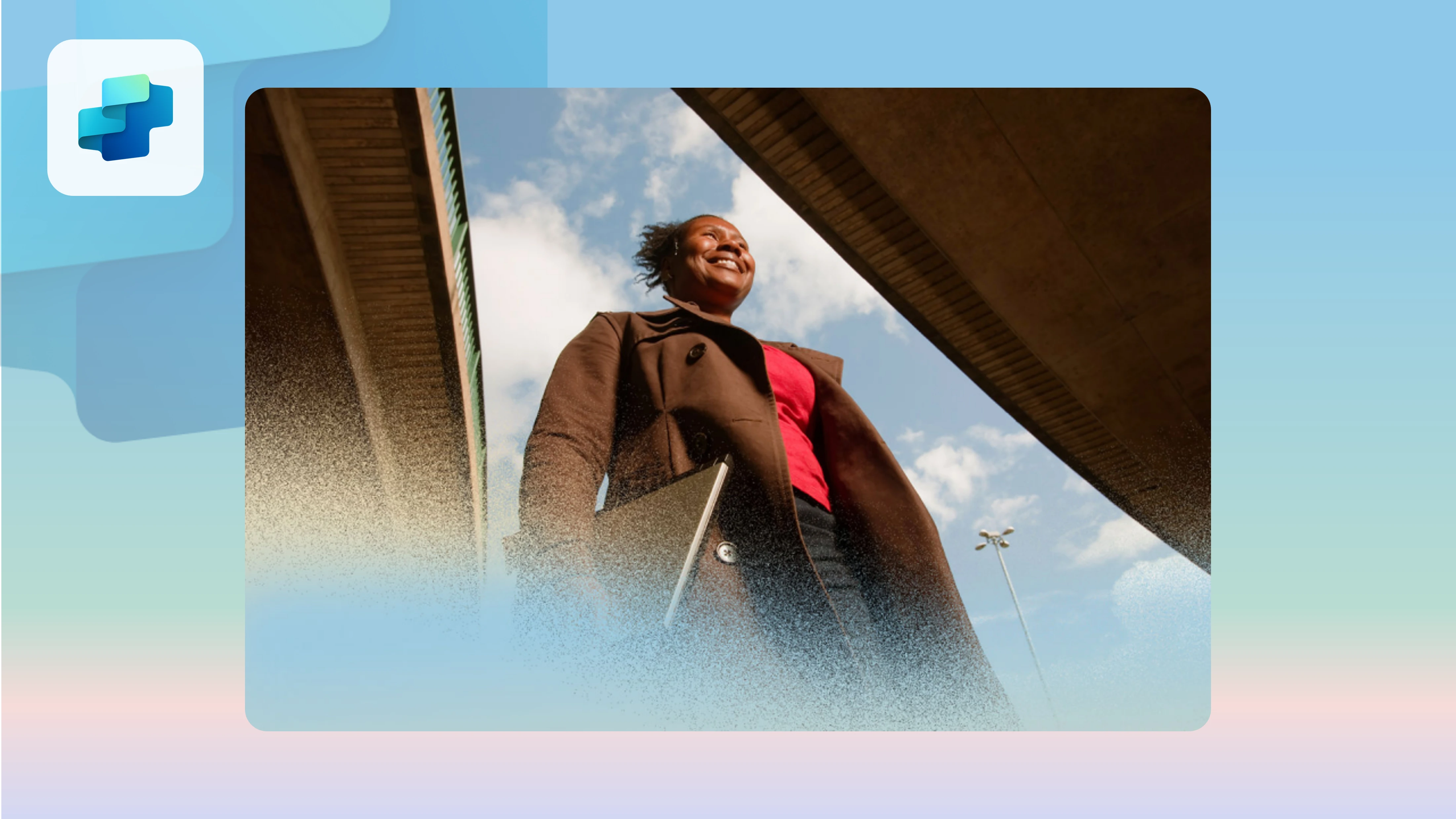 A smiling woman walking to work carrying her laptop