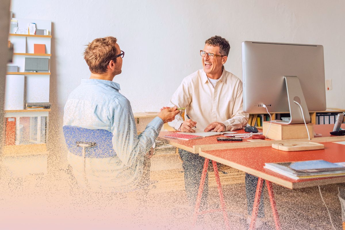 Two men collaborating joyfully at work