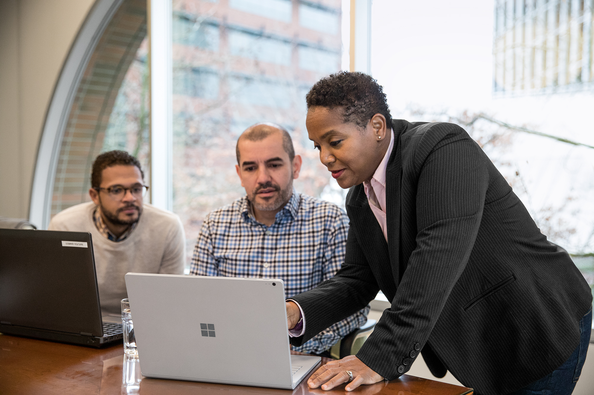a group of people looking at a laptop