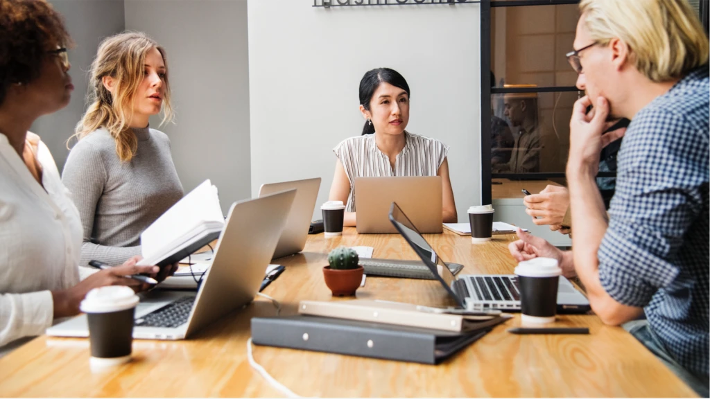 A group of colleagues in discussion in a conference room.