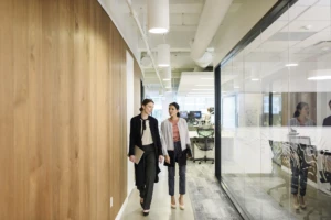 Two people walking down a hallway.