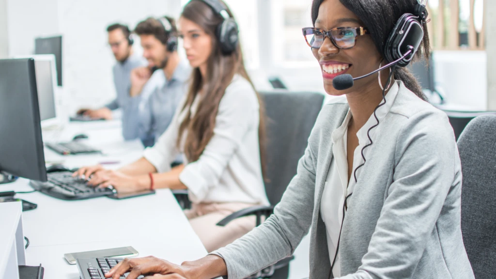 A group of customer service representatives with headsets on.