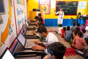 Students learn basic computer skills on laptop computers in classroom of a primary school near Delhi.