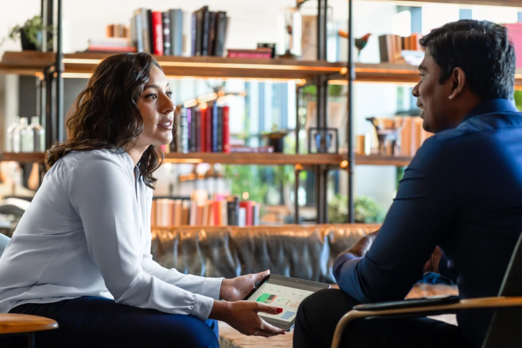 Two people meeting in the hotel lobby ahead of client presentation.