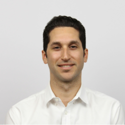 a man wearing a white shirt and smiling at the camera