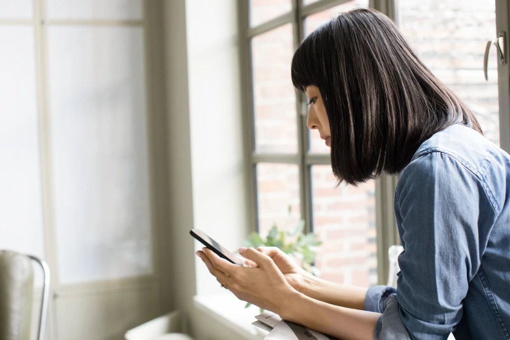 Female using phone in family room.