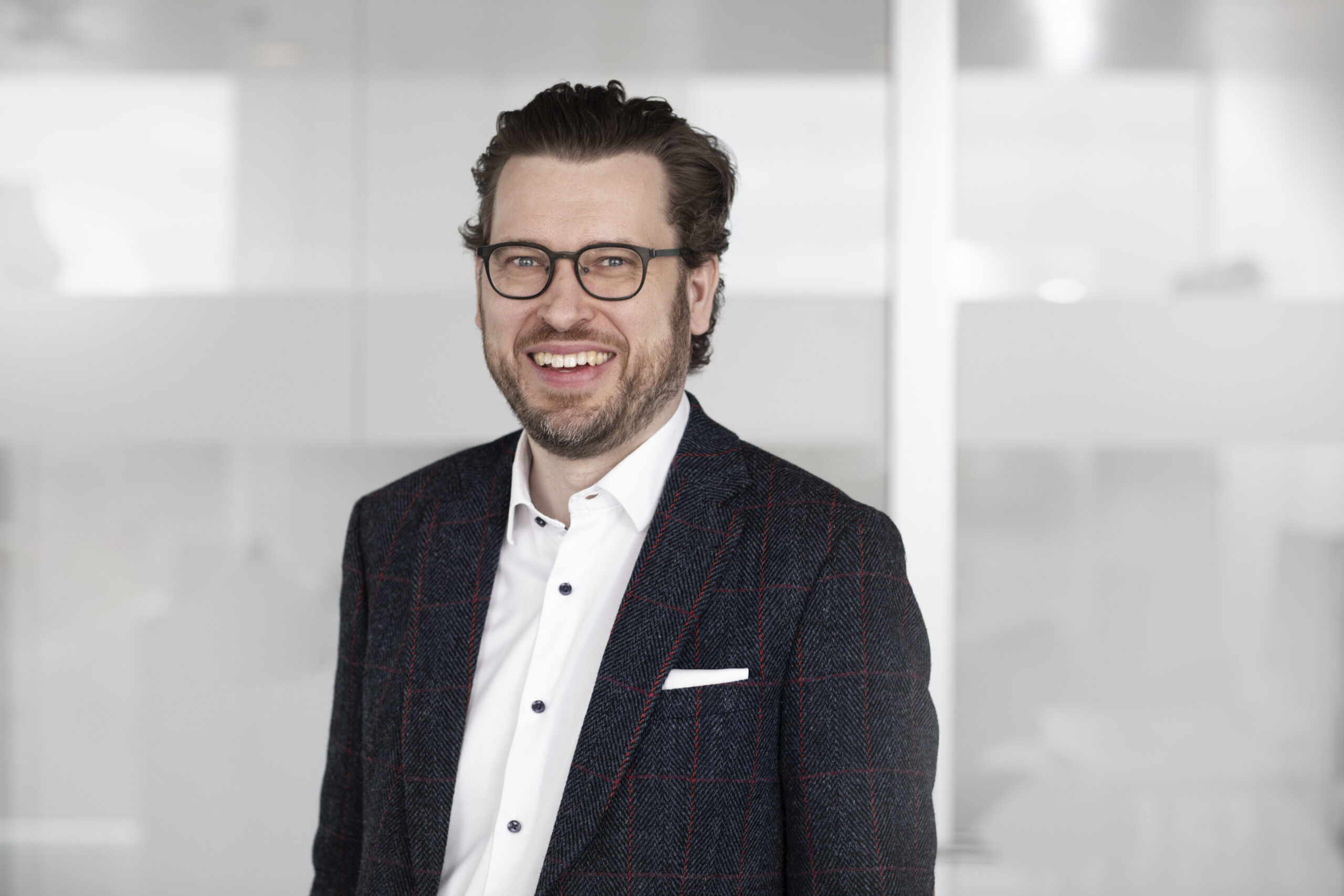 Professional portrait of a person wearing a dark jacket indoors