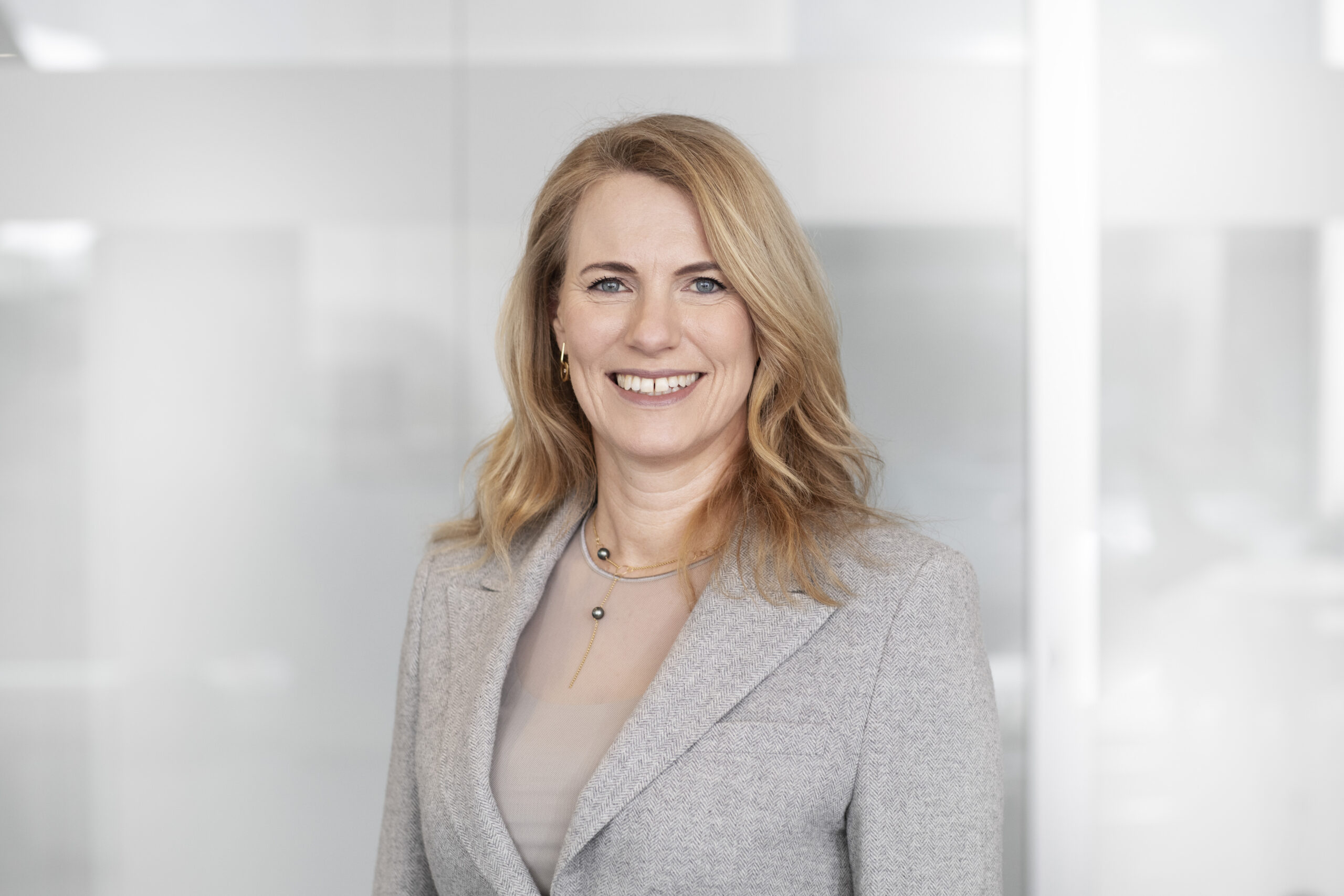 Professional portrait of a person wearing a light blazer indoors